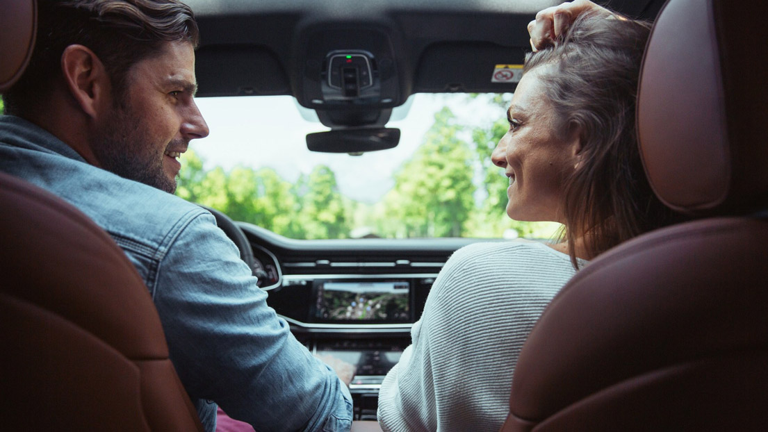 Mann und Frau sitzen in einem Audi