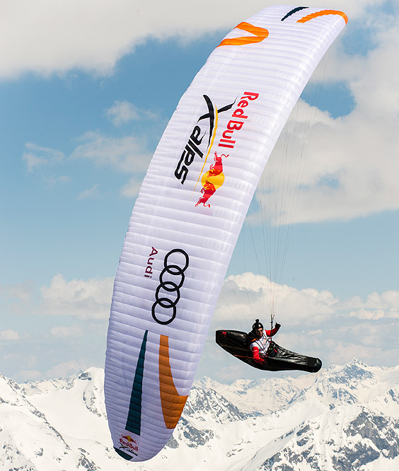 Paragleiter mit weißem Schirm fliegt durch die Luft