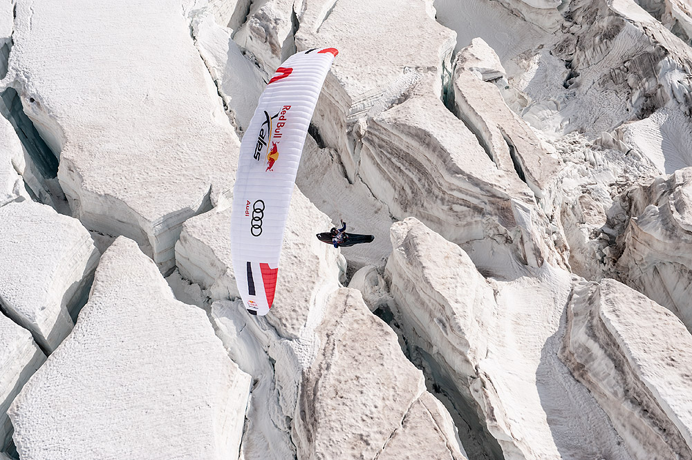 Paragleiter mit weißem Schirm fliegt durch die Luft