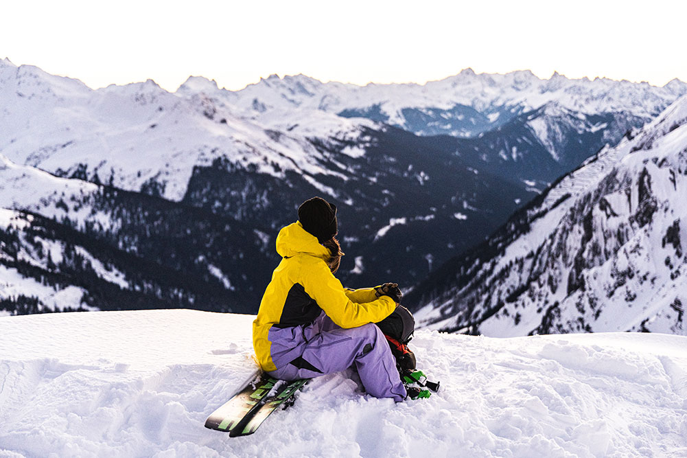 Lorraine Huber sitzt im Schnee auf einem Berg